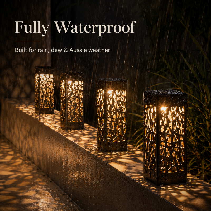 Four black metal outdoor lanterns with intricate cutout patterns, glowing with warm light on a wet stone ledge in the rain. White text at the top reads 'Fully Waterproof' and 'Built for rain, dew & Aussie weather'.